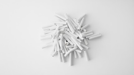 A minimalist composition featuring a loose pile of scattered cigarettes on a smooth white background, creating a clean and modern feel.