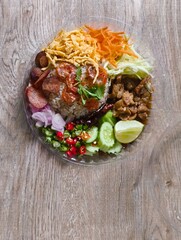 Khao Kluk Kapi, a popular dish in Thailand or Shrimp Paste Fried Rice Including of rice mixed with fragrant shrimp paste, Chinese sausage, sweet pork, shredded egg, dried shrimp, lime, yard long beans