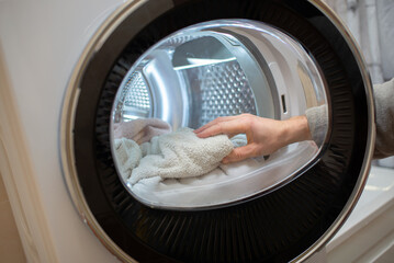 View of the tumble dryer or dryer machine with the door open and a towel inside