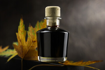 Bottiglietta di aceto balsamico, condimento tipico di Modena, isolata su fondo scuro, primo piano