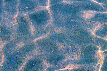 Blue Through the transparent water of the ocean or sea you can see the sandy bottom with ridges of...