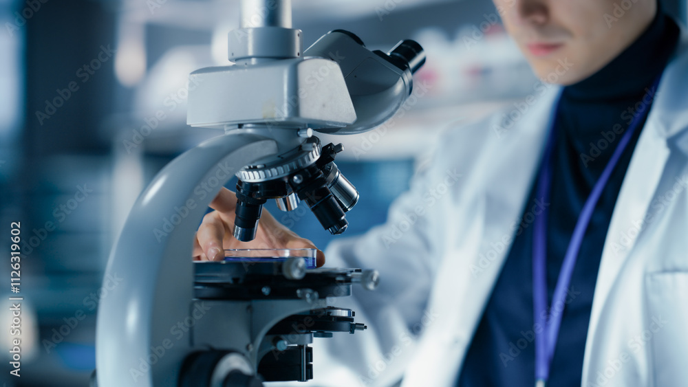 Poster Medical Research and Development Laboratory: Close Up of a Male Scientist Preparing a Biological Sample in a Petri Dish in a Microscope in an Advanced Biotechnology Lab