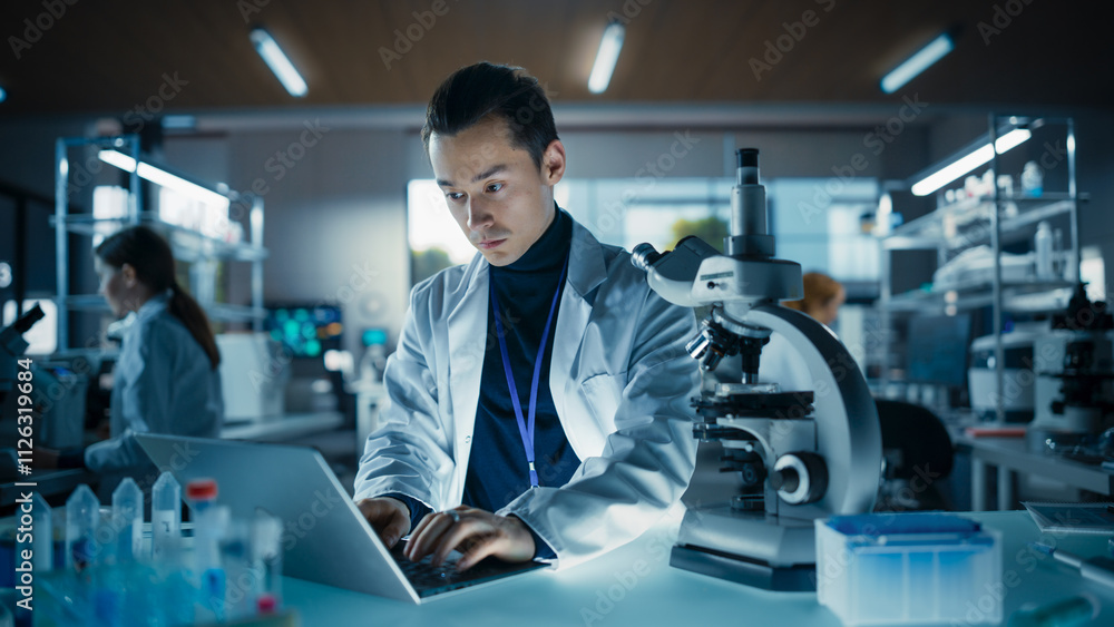 Poster portrait of a young graduate student working in a laboratory, using advanced microscope, writing dow