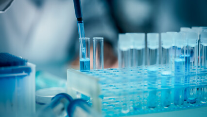 Close Up of an Anonymous Scientist Conducting Experiments for Pharmaceutical Development. Researcher Using a Micropipette for Filling Special Laboratory Glassware with Liquid Samples