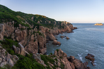 Serene Coastal Landscape with Rugged Cliffs and Calm Waters