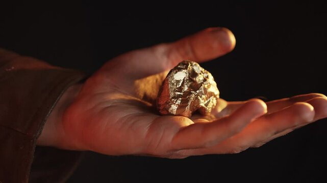 Miner Holding a Golden Nugget, Symbol of Hard Work and Success