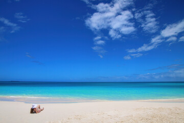 Woman relaxing on Fayaoue beach on the coast of Ouvea lagoon, Mouli and Ouvea Islands, New Caledonia