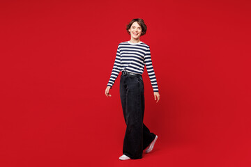 Full body side view young smiling cheerful Caucasian happy woman she wear blue striped sweatshirt...