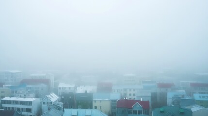 Foggy urban landscape obscuring buildings and rooftops.