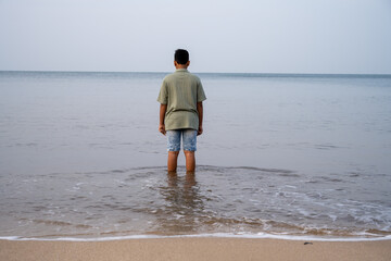 lonely boy looking at the the beach.