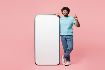 Full body young Indian man he wear blue t-shirt casual clothes big huge blank screen mobile cell...