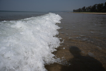 Soft wave of blue ocean on sandy beach.