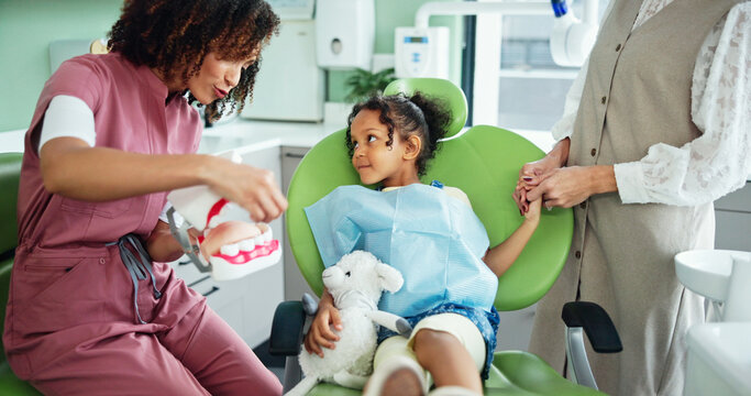Dentist, consulting and woman with child in clinic for tooth extraction, cleaning and wellness. Healthcare, dentistry and young patient with model for dental hygiene, oral care and medical services - Powered by Adobe