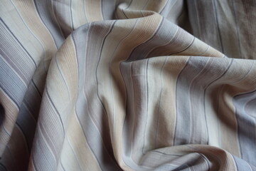 light beige, blue and grey striped cotton fabric in soft folds