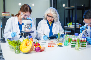 A male scientist and two women conduct plant research in a laboratory.  microscopes, petri...