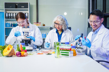 A male scientist and two women conduct plant research in a laboratory.  microscopes, petri dishes,test tubes to analyze genetically modified plants, food, meat, eggs,vegetables for nutritional value