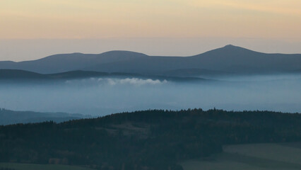 Colorful sunset over the Czech countryside. View from the Teplice-Adršpašské rocks of the Giant Mountains and the surrounding hills.