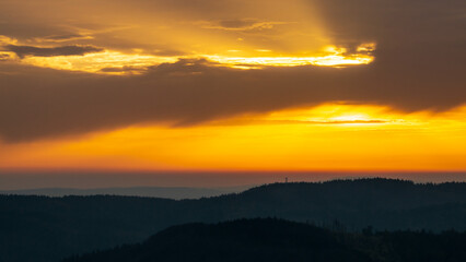 Colorful sunset over the Czech countryside. View from the Teplice-Adršpašské rocks of the Giant Mountains and the surrounding hills.
