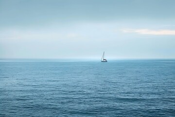 Obraz premium A serene image of a small sailboat peacefully navigating a vast expanse of calm, azure ocean.