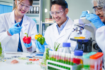 A male scientist and two women conduct plant research in a laboratory.  microscopes, petri dishes,test tubes to analyze genetically modified plants, food, meat, eggs,vegetables for nutritional value