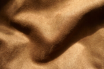 Soft folds on chocolate brown faux suede polyester fabric
