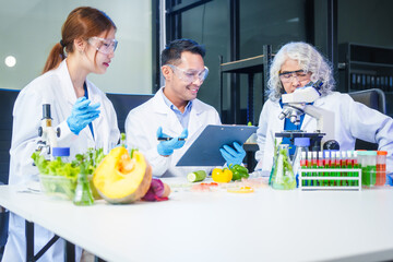 A male scientist and two women conduct plant research in a laboratory.  microscopes, petri dishes,test tubes to analyze genetically modified plants, food, meat, eggs,vegetables for nutritional value