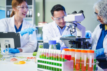 A male scientist and two women conduct plant research in a laboratory.  microscopes, petri dishes,test tubes to analyze genetically modified plants, food, meat, eggs,vegetables for nutritional value