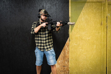 A man in civilian clothes practices tactical shooting with night vision monocular and a ak rifle...