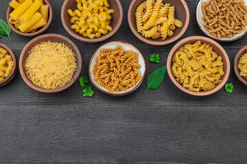 Pasta. Various kinds of uncooked pasta and noodles over wooden background. Traditional Italian