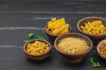 Pasta. Various kinds of uncooked pasta and noodles over wooden background. Traditional Italian
