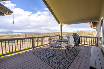 Scenic outdoor patio with a grill overlooking arid landscape under a cloudy sky in a serene setting