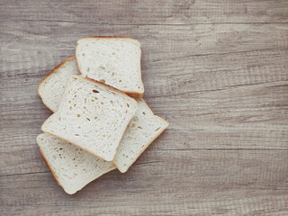 Square pieces of white toast bread on a wooden background	