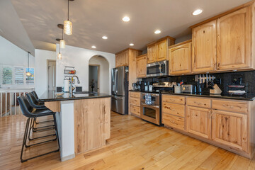 Modern kitchen design featuring wooden cabinets and sleek appliances in a spacious layout