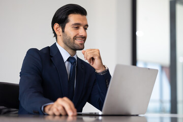 Male sitting on desk with laptop computer. Portrait of Confident successful business people woking...