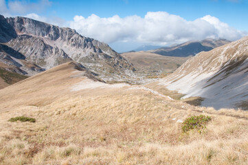 Grass-covered slopes of Caucasus mountains in autumn with a part of the Mount Pshekhu-Su in the...
