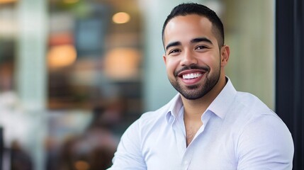 Obraz premium A smiling man in a light shirt poses confidently outside a café, radiating positivity and approachability.