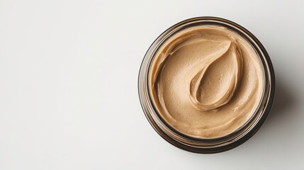 Swirled creamy foundation in jar on white