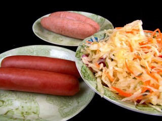 Sausage and salad on plates background