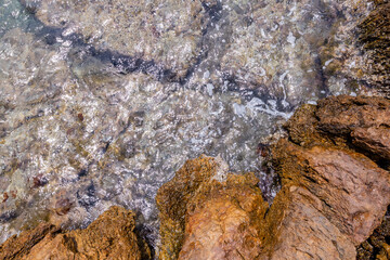 Ocean Waves Washing Over Rocky Shoreline with Crystal Clear Waters