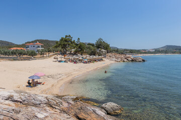 Fototapeta premium : Crystal-clear waters gently flowing over a rocky beach in Thassos, Greece, showcasing natural coastal beauty.