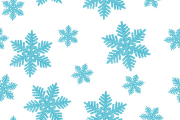 Fototapeta premium Seamless pattern made of top view of traditional shiny glittering snowflakes christmas bauble or new year decoration of blue colour isolated on white background used for winter holiday greeting decor