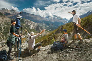 Happy hikers with backpacks in mountains enjoying scenic on view of mountains during hike in...