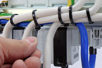 Installation of a plastic ties on electrical insulated mounting wires. Close-up. Soft focus.