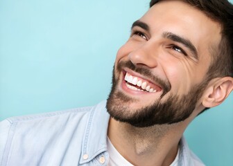 Fototapeta premium Close up view of happy man with white teeth smiling broadly. Man beard, wearing light colored shirt. Pastel blue background. Image suitable for dentistry clinic ad. Concept teeth whitening, healthy