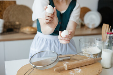 Girl confectioner holding chicken eggs in her hands