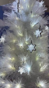4k footage close up of lighted Christmas tree ornaments and decorations. Mistletoe, baubles, and bell with Interactive sparkling christmas twinkle lights or icicle lights.