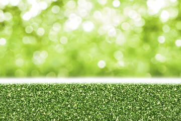 Sparkling green glitter texture against a blurred green background, perfect for adding a touch of festive sparkle to your designs.