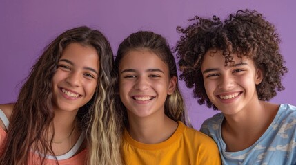 Fototapeta premium Three young individuals with dark curly hair smiling and posing together in front Of a purple background.