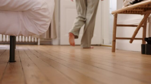 Woman In Pajamas Walking To The Door Of Bedroom. - low-level shot