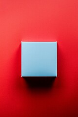 A square blue empty box is located in the center of an entirely plain red background,